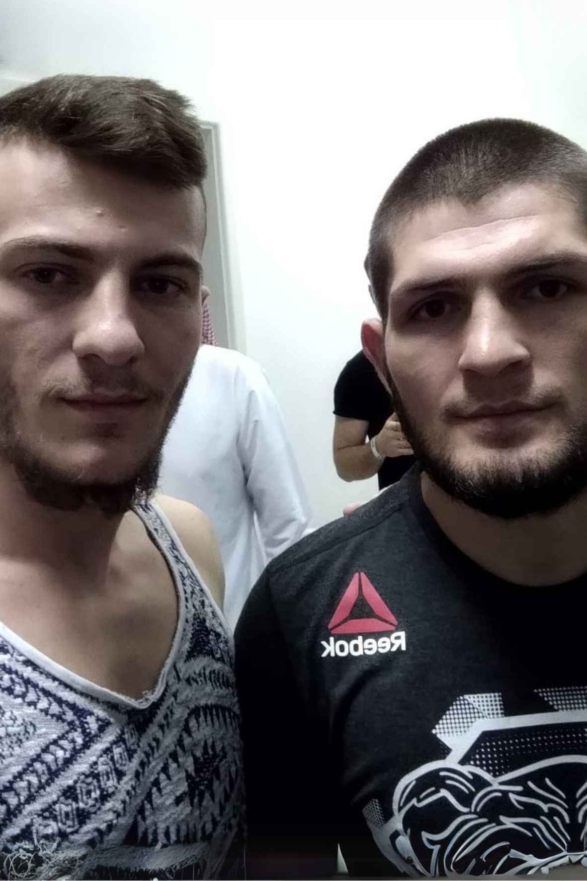 Selfie di Marco insieme a Khabib Nurmagomedov in una stanza bianca, con altre due persone sullo sfondo